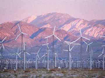 Photo of electric generating windmills and mountains behind